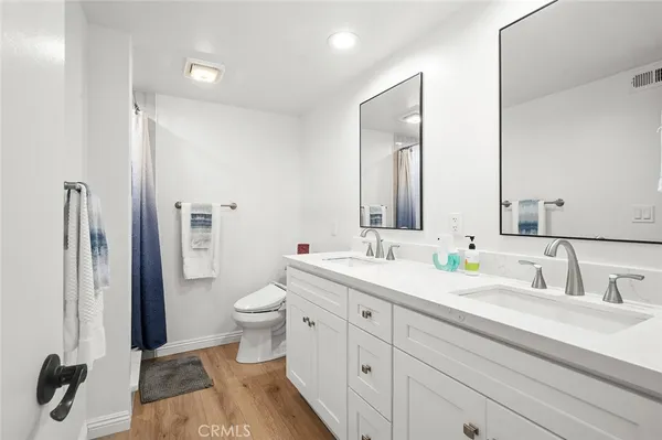 a spacious bathroom with a double vanity sink mirror and toilet