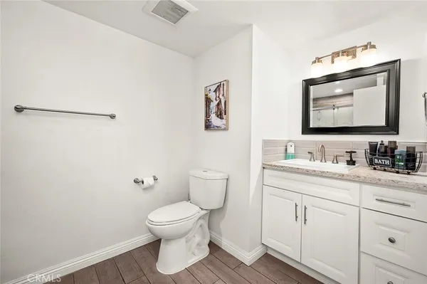 a bathroom with a toilet sink vanity and mirror