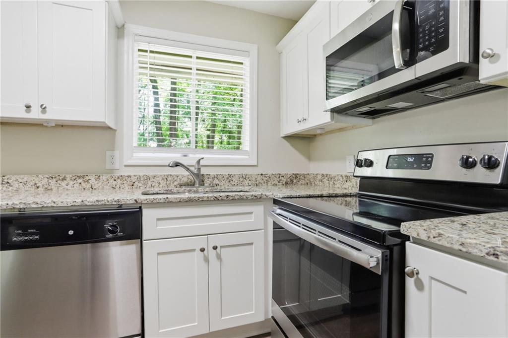 4505 Wonder Valley Trail Decatur, GA 30034 - Photo 9 of 34 a kitchen with granite countertop a stove sink and microwave