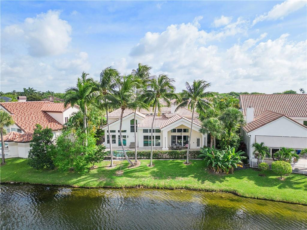 3110 Northwest 63rd Street Boca Raton, FL 33496 - Photo 4 of 62 a view of a white house with a big yard and palm trees
