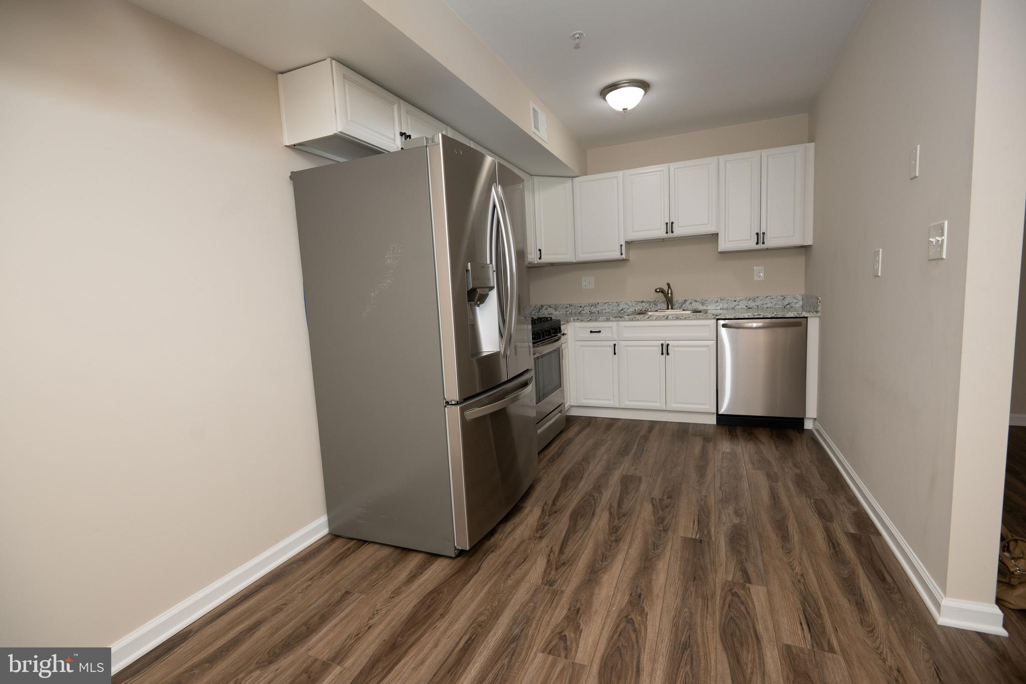 411 Stiles Avenue, Unit E3 Maple Shade, NJ 08052 - Photo 20 of 30 a kitchen with a refrigerator and white cabinets