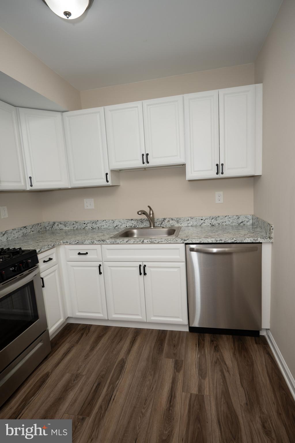 411 Stiles Avenue, Unit E3 Maple Shade, NJ 08052 - Photo 25 of 30 a kitchen with granite countertop white cabinets and white appliances