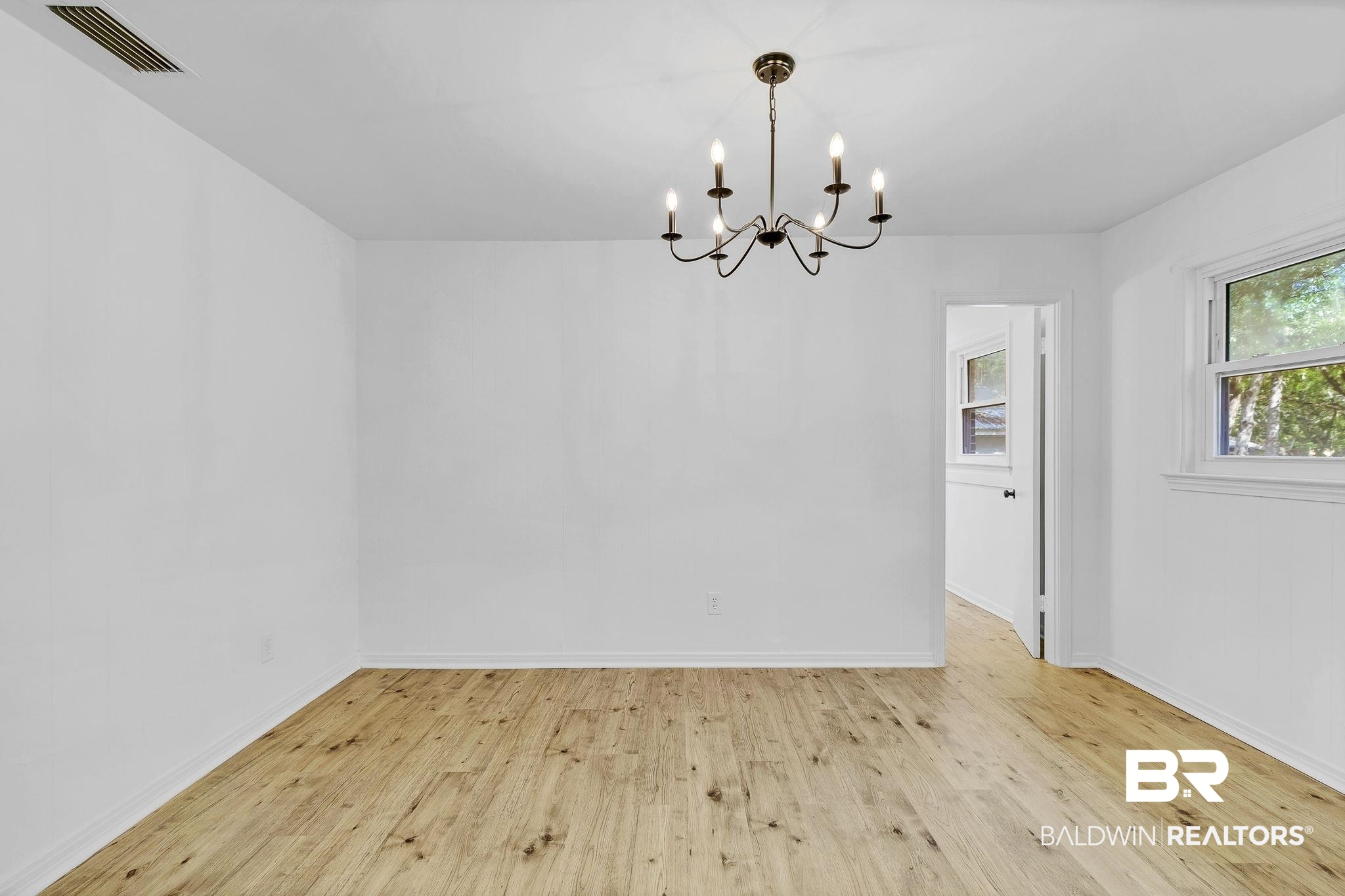 203 Anderson Road Saraland, AL 36571 - Photo 10 of 48 Unfurnished dining area featuring visible vents, baseboards, an inviting chandelier, and light wood-style floors