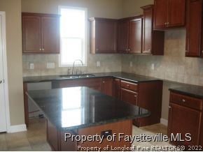 Lot 104 Carl Steiner Road Fayetteville, NC 28311 - Photo 3 of 15 a kitchen with granite countertop a sink window and cabinets
