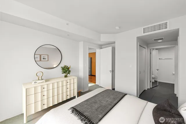 a bedroom with furniture a mirror and a window