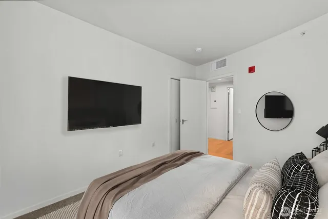a bedroom with a bed and a flat screen tv