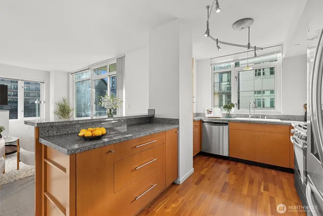 a kitchen with granite countertop a sink and wooden floor