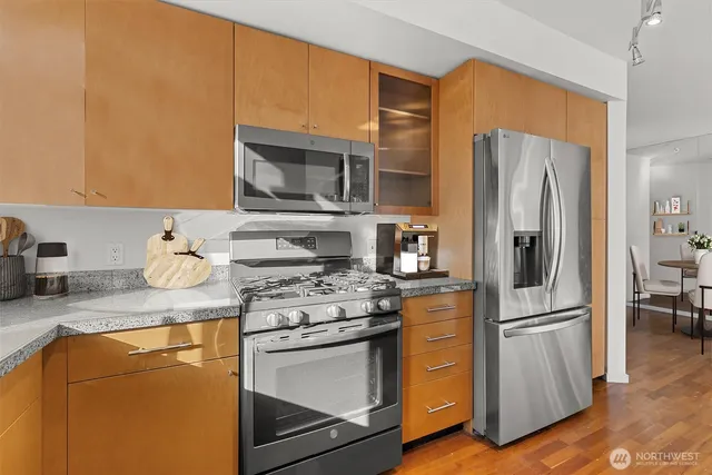 a kitchen with stainless steel appliances granite countertop a refrigerator stove and sink