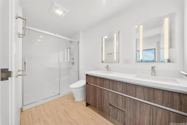a bathroom with a double vanity sink toilet and shower