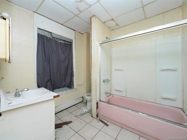 a bathroom with a bathtub shower sink and a toilet