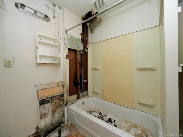 a bathroom with a tub a sink and a shower