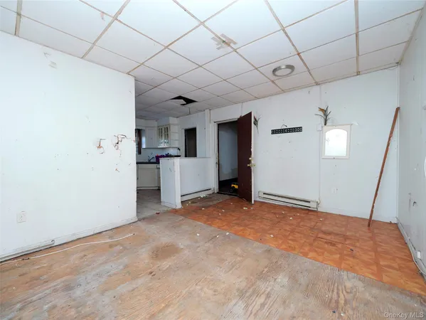 a view of empty room with kitchen and window