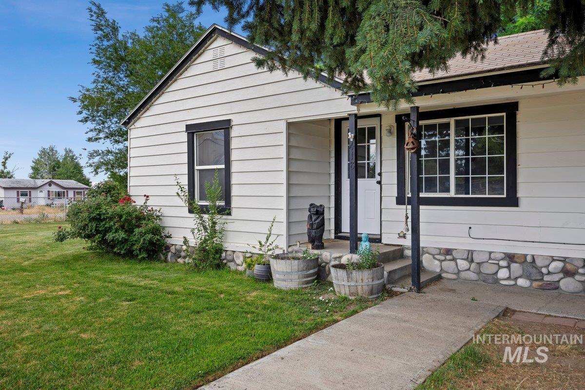 418 South Date Street Shoshone, ID 83352 - Photo 2 of 36 White horizontal siding exterior with black trim and a stone foundation