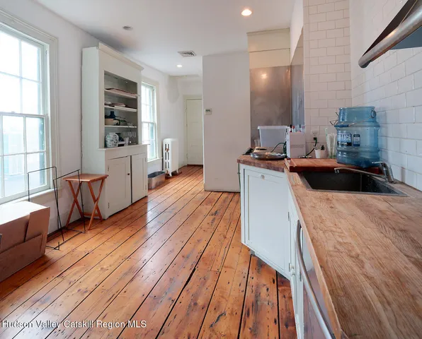 a kitchen with stainless steel appliances wooden floors and wooden cabinets