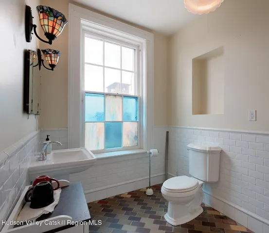 a bathroom with a toilet a sink and a window