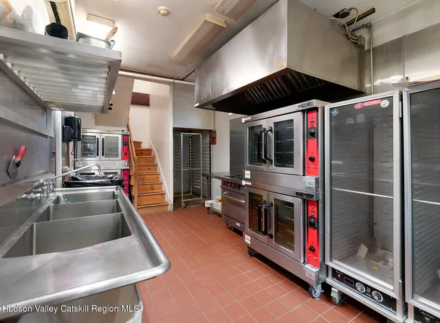 a kitchen with stainless steel appliances kitchen island granite countertop a stove and a sink