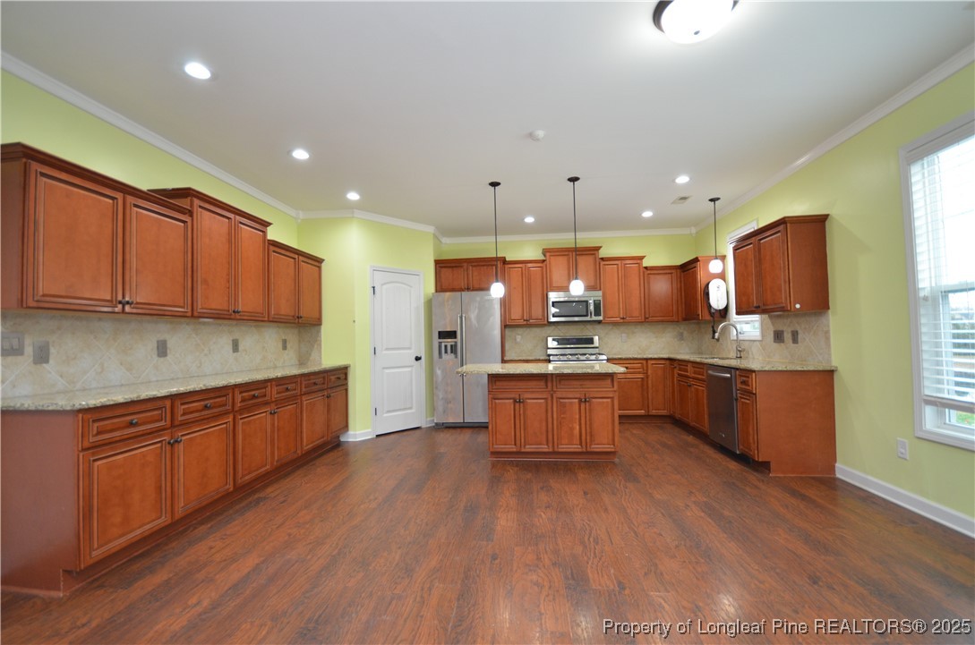 281 Ganton Drive Raeford, NC 28376 - Photo 12 of 50 a large kitchen with stainless steel appliances wooden floors wooden cabinets a center island and a window