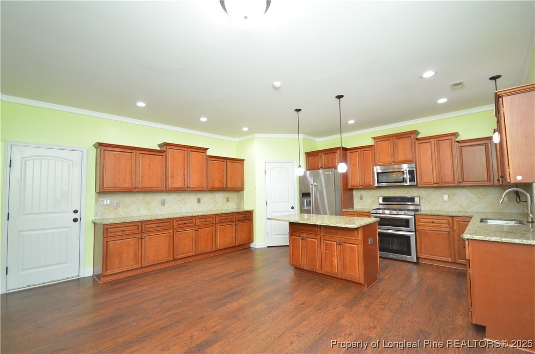 281 Ganton Drive Raeford, NC 28376 - Photo 14 of 50 a kitchen with stainless steel appliances a stove top oven a sink dishwasher and a refrigerator with wooden floor
