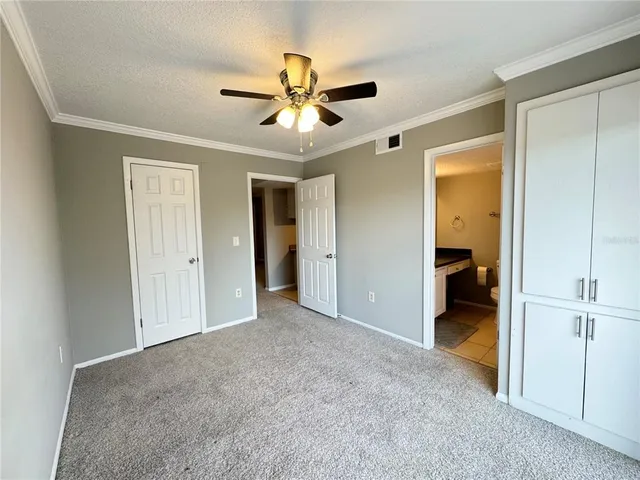 a view of a big room with closet and a ceiling fan