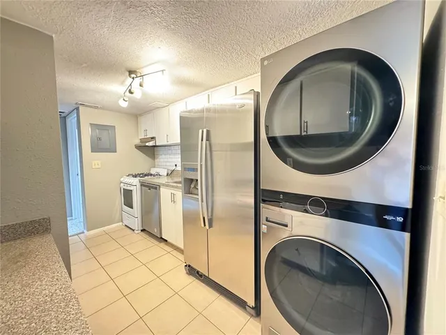 a kitchen with stainless steel appliances granite countertop a refrigerator and a stove top oven