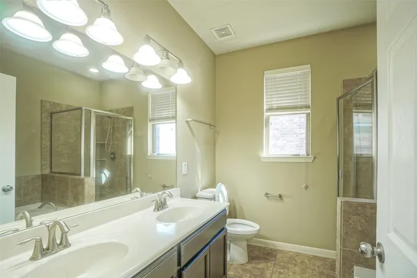 a bathroom with a sink a toilet and a mirror
