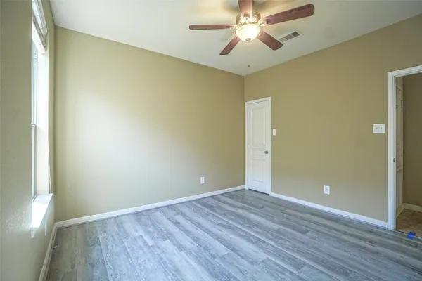 a view of an empty room with wooden floor