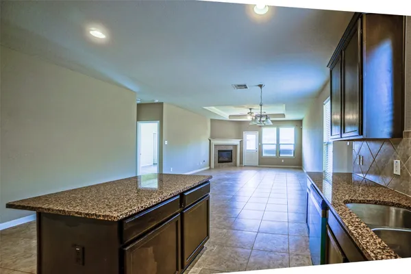 a kitchen with granite countertop a sink cabinets and window