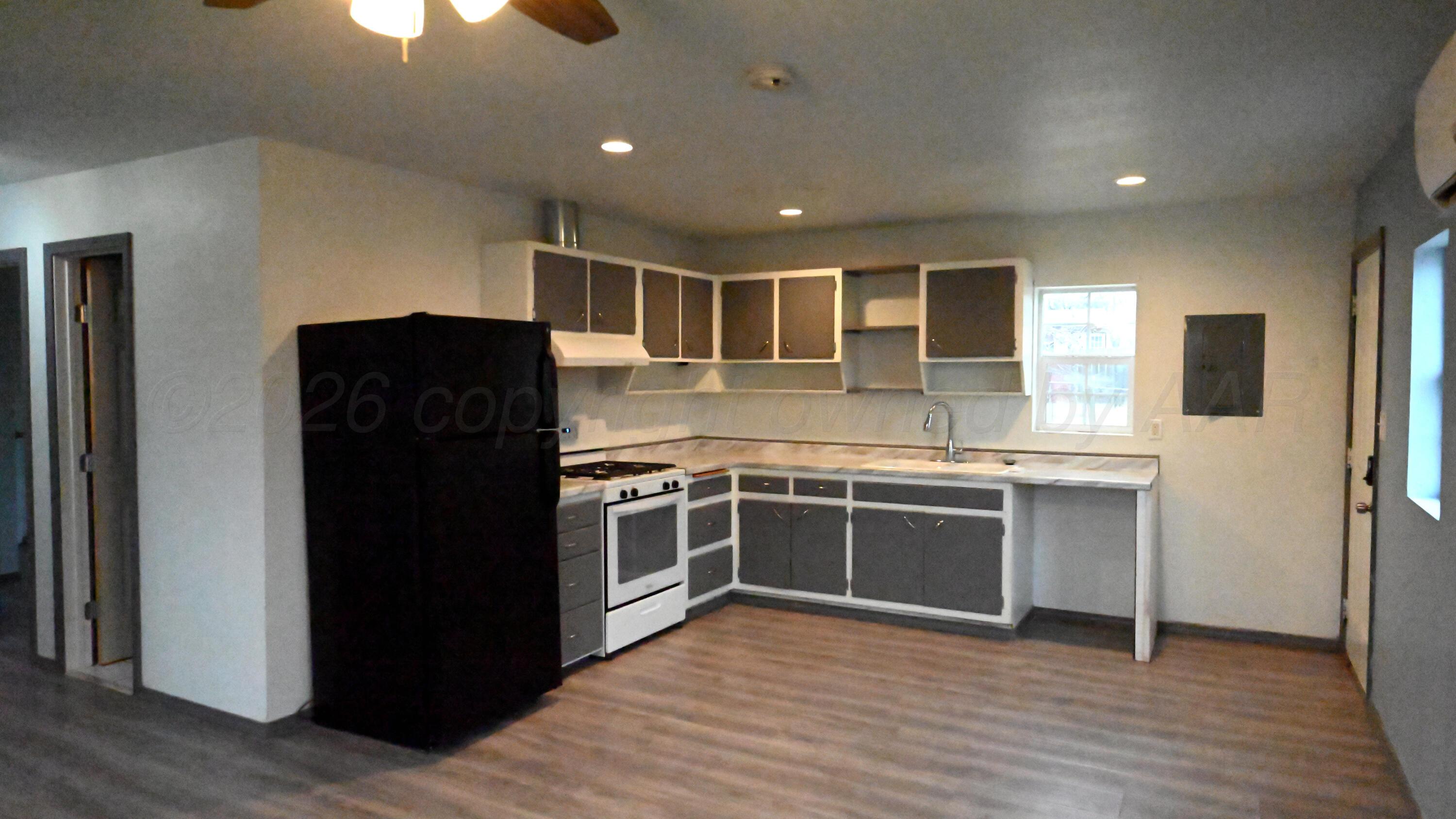 306 Union Street Borger, TX 79007 - Photo 3 of 12 a kitchen with stainless steel appliances granite countertop a refrigerator and a sink