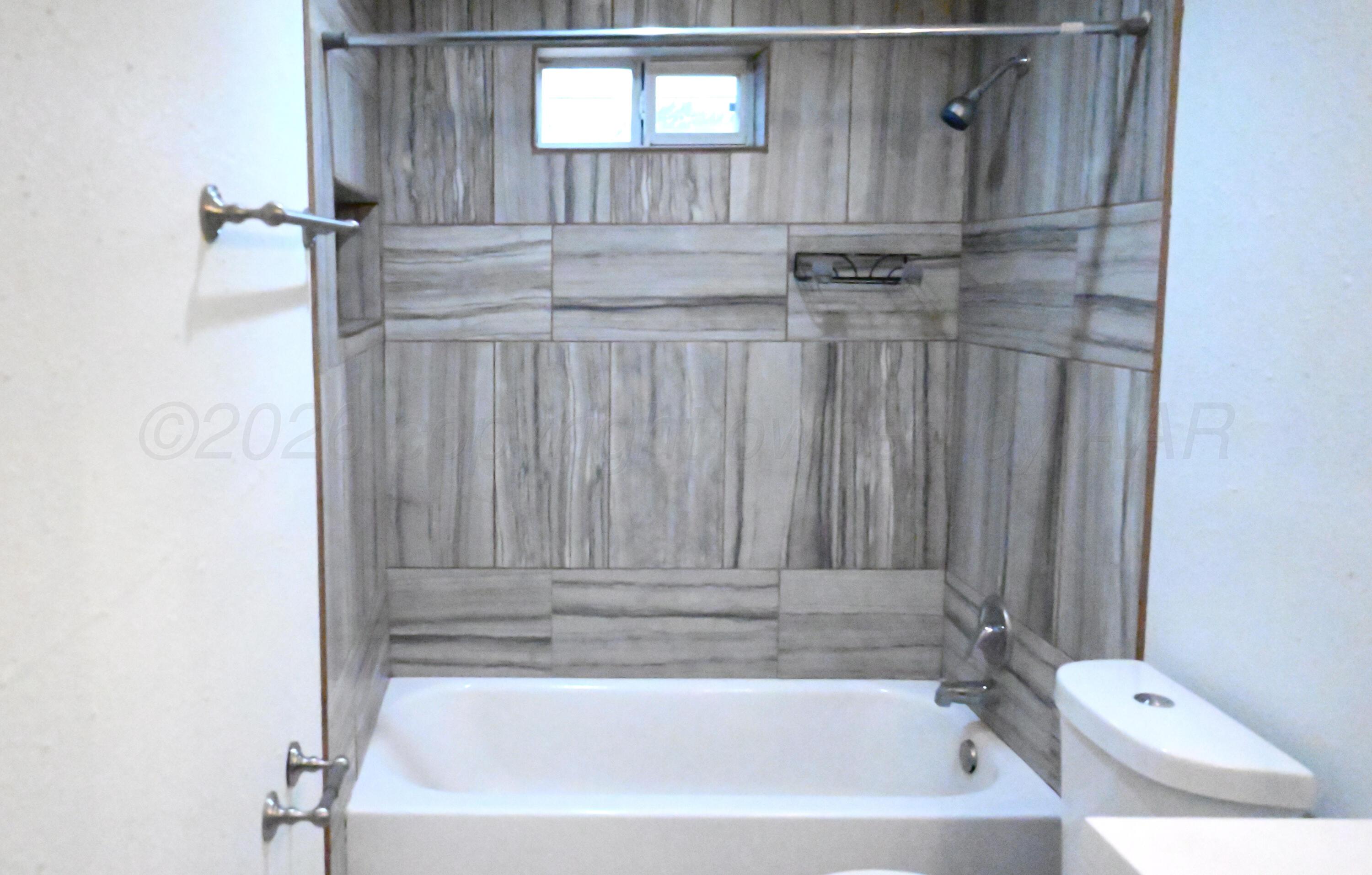 306 Union Street Borger, TX 79007 - Photo 6 of 12 a bathroom with a bathtub and a shower