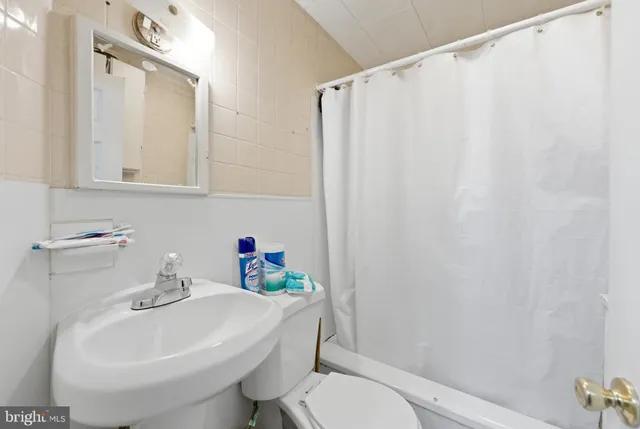 a bathroom with a sink a toilet and shower curtain