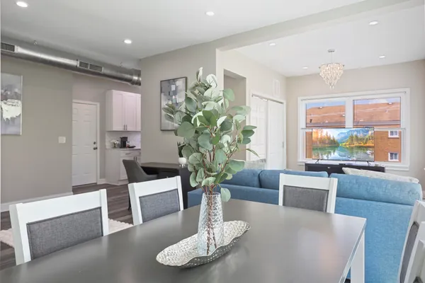 a living room with furniture potted plant and wooden floor