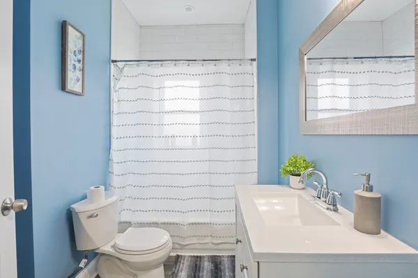 a bathroom with a sink a toilet and a mirror