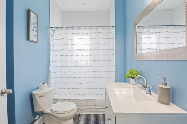 a bathroom with a sink a toilet and a mirror