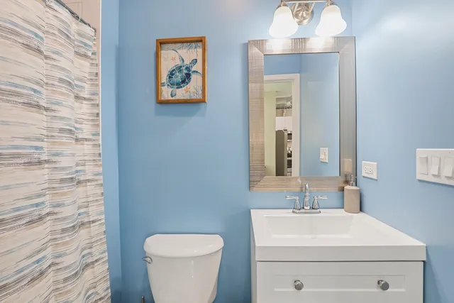 a bathroom with a toilet a sink and mirror