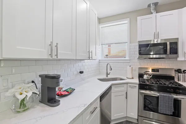 a kitchen with a sink stove and white cabinets