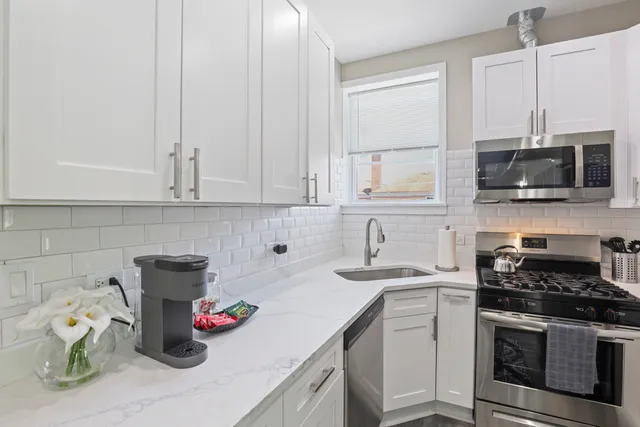 a kitchen with a sink stove and white cabinets
