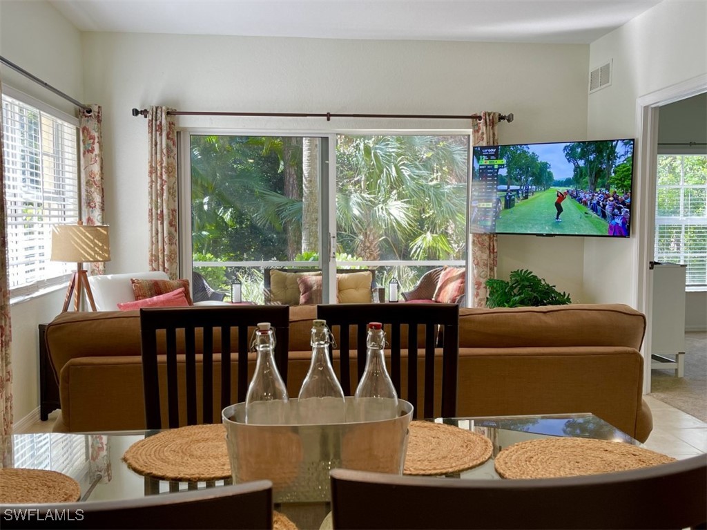 4440 Botanical Pl Circle, Unit 102 Naples, FL 34112 - Photo 4 of 21 a living room with furniture and a floor to ceiling window