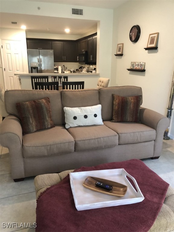 4440 Botanical Pl Circle, Unit 102 Naples, FL 34112 - Photo 5 of 21 a living room with furniture and a view of kitchen