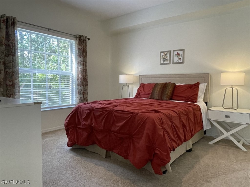 4440 Botanical Pl Circle, Unit 102 Naples, FL 34112 - Photo 7 of 21 a bed sitting in a bedroom next to a window