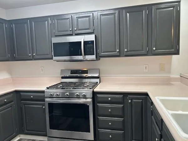 a kitchen with a sink stove and cabinets