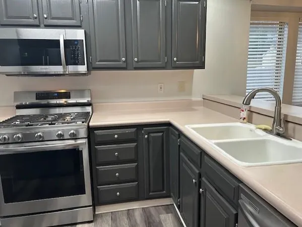 a kitchen with a sink cabinets and a window