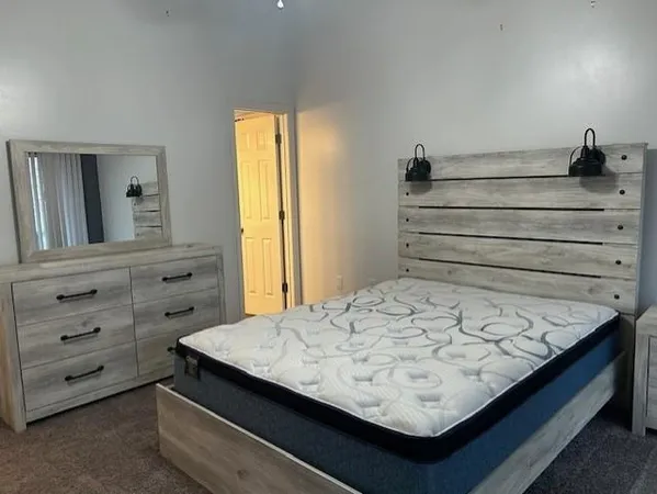 a view of a bedroom with a bed and a window