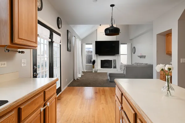 a living room with stainless steel appliances furniture a fireplace and a flat screen tv