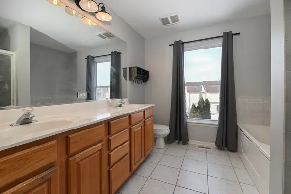 a spacious bathroom with a granite countertop sink mirror and bathtub