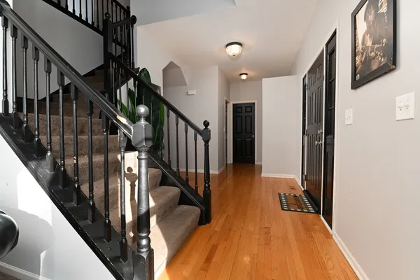 a view of a hallway with wooden floor and staircase