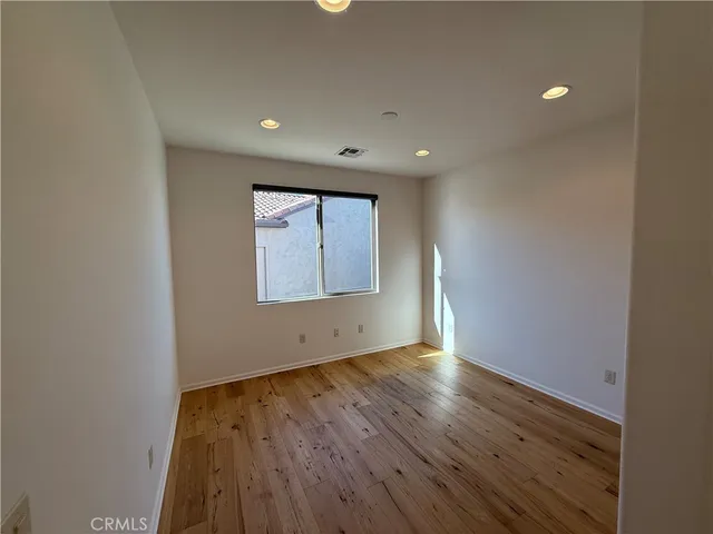 a spacious bedroom with a large bed and a chandelier fan