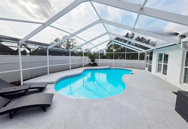 a view of a swimming pool with a patio and yard of the house