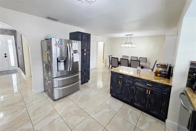 a kitchen with stainless steel appliances granite countertop a refrigerator and a sink