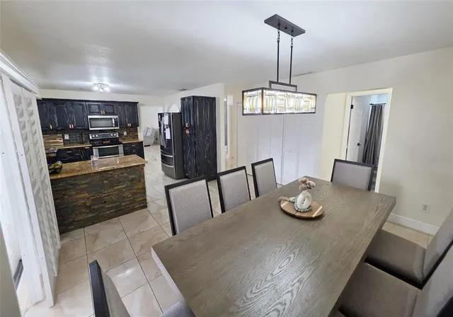 a view of a dining room with furniture a chandelier and wooden floor