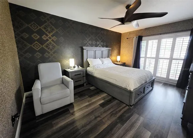 a bedroom with a bed wooden floor and window